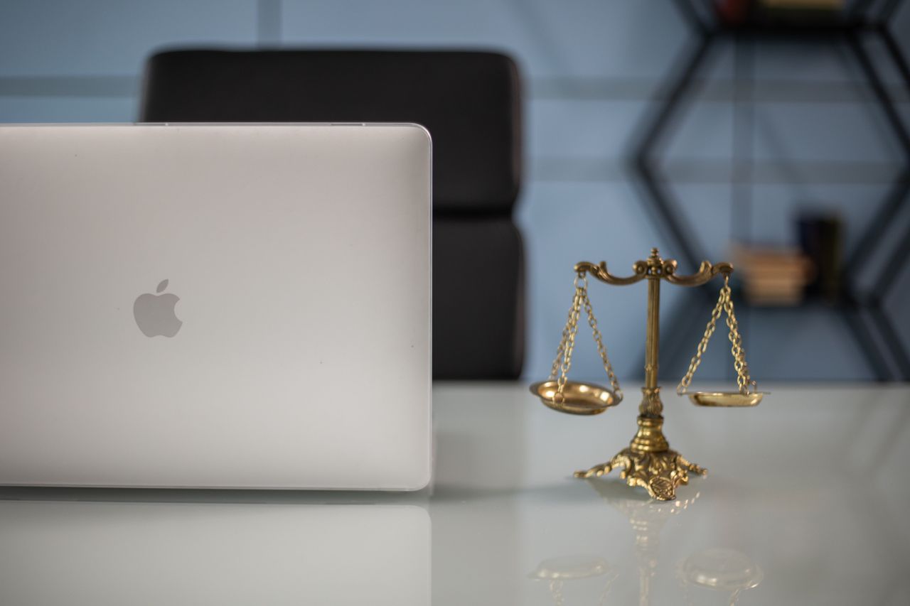 Services Elegant balance of technology and justice scales on an office desk.