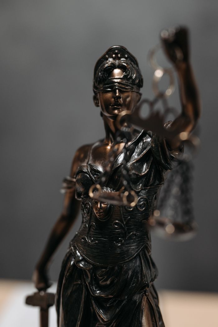 Services Detailed bronze statue of Lady Justice with scales, symbolizing law and justice.